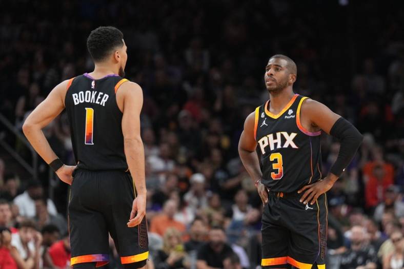 Oct 30, 2022; Phoenix, Arizona, USA; Phoenix Suns guard Devin Booker (1) and Phoenix Suns guard Chris Paul (3) look on against the Houston Rockets during the first half at Footprint Center. Mandatory Credit: Joe Camporeale-USA TODAY Sports