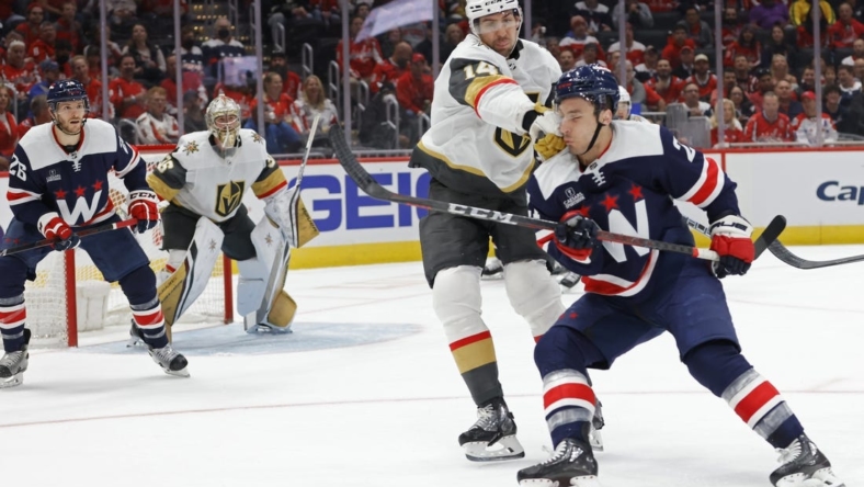 Nov 1, 2022; Washington, District of Columbia, USA; Vegas Golden Knights defenseman Nicolas Hague (14) punches Washington Capitals right wing Garnet Hathaway (21) while battling for the puck in the first period at Capital One Arena. Mandatory Credit: Geoff Burke-USA TODAY Sports
