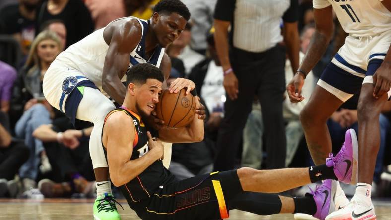 Nov 1, 2022; Phoenix, Arizona, USA; Phoenix Suns guard Devin Booker (bottom) battles for a loose ball with Minnesota Timberwolves guard Anthony Edwards in the first half at Footprint Center. Mandatory Credit: Mark J. Rebilas-USA TODAY Sports