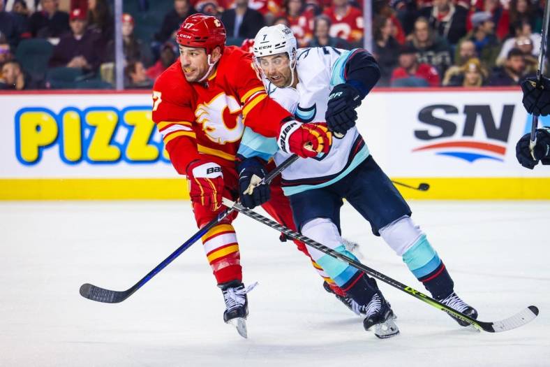 Nov 1, 2022; Calgary, Alberta, CAN; Calgary Flames left wing Milan Lucic (17) and Seattle Kraken right wing Jordan Eberle (7) battle for the puck during the third period at Scotiabank Saddledome. Mandatory Credit: Sergei Belski-USA TODAY Sports