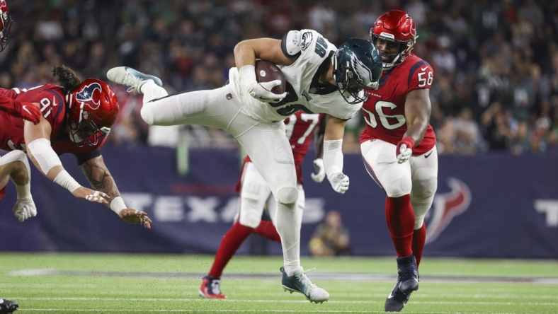 Nov 3, 2022; Houston, Texas, USA; Philadelphia Eagles tight end Dallas Goedert (88) leaps with the ball as Houston Texans defensive tackle Thomas Booker IV (56) defends during the second quarter at NRG Stadium. Mandatory Credit: Troy Taormina-USA TODAY Sports