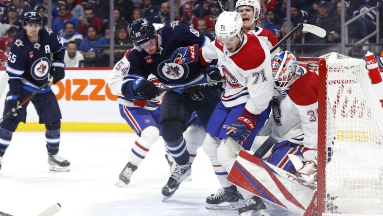 Nov 3, 2022; Winnipeg, Manitoba, CAN; Winnipeg Jets left wing Pierre-Luc Dubois (80) and Montreal Canadiens center Jake Evans (71) look for a rebound in front of Montreal Canadiens goaltender Sam Montembeault (35) in the second period at Canada Life Centre. Mandatory Credit: James Carey Lauder-USA TODAY Sports