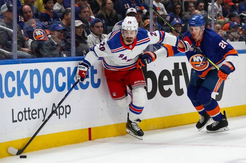 Oct 26, 2022; Elmont, New York, USA; New York Rangers left wing Chris Kreider (20) moves the puck past New York Islanders defenseman Scott Mayfield (24) during the first period at UBS Arena. Mandatory Credit: Tom Horak-USA TODAY Sports