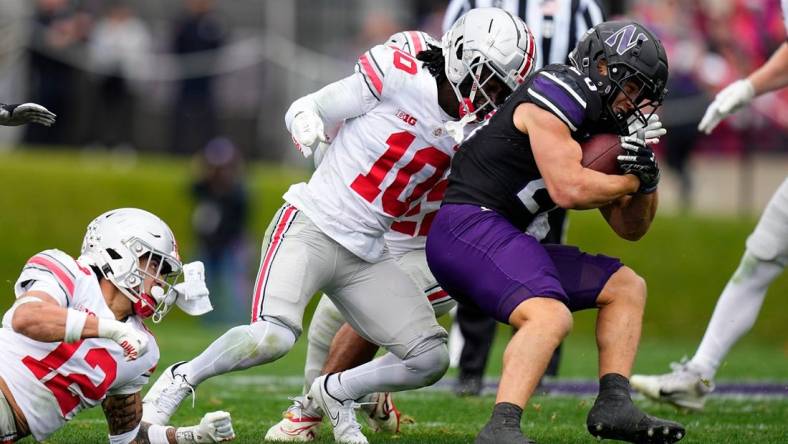 Nov 5, 2022; Evanston, Illinois, USA; Ohio State Buckeyes cornerback Denzel Burke (10) tackles Northwestern Wildcats running back Evan Hull (26) during the first half of the NCAA football game at Ryan Field. Mandatory Credit: Adam Cairns-The Columbus Dispatch

Ncaa Football Ohio State Buckeyes At Northwestern Wildcats