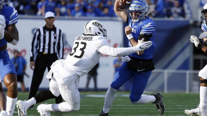 Nov 5, 2022; Memphis, Tennessee, USA; Memphis Tigers quarterback Seth Henigan (5) runs the ball as UCF Knights defensive end Tre'mon Morris-Brash (33) attempts to make the tackle during the first half at Liberty Bowl Memorial Stadium. Mandatory Credit: Petre Thomas-USA TODAY Sports