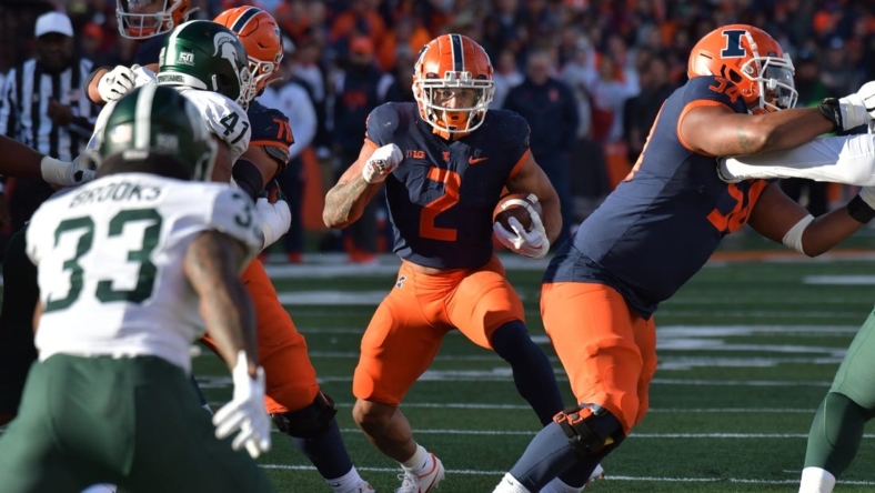 Nov 5, 2022; Champaign, Illinois, USA;  Illinois Fighting Illini running back Chase Brown (2) runs through an opening against the Michigan State Spartans during the first half at Memorial Stadium. Mandatory Credit: Ron Johnson-USA TODAY Sports