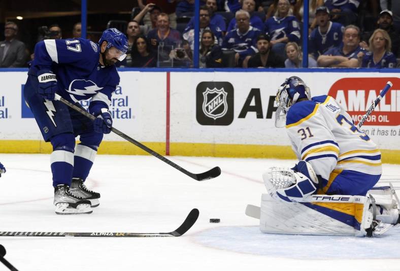 Nov 5, 2022; Tampa, Florida, USA;Tampa Bay Lightning left wing Alex Killorn (17) passes the puck as Buffalo Sabres goaltender Eric Comrie (31) defends  during the first period at Amalie Arena. Mandatory Credit: Kim Klement-USA TODAY Sports