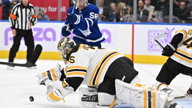 Nov 5, 2022; Toronto, Ontario, CAN; Boston Bruins goalie Linus Ullmark (35) dives to reach a loose puck ahead of Toronto Maple Leafs forward Michael Bunting (58) in the second period at Scotiabank Arena. Mandatory Credit: Dan Hamilton-USA TODAY Sports