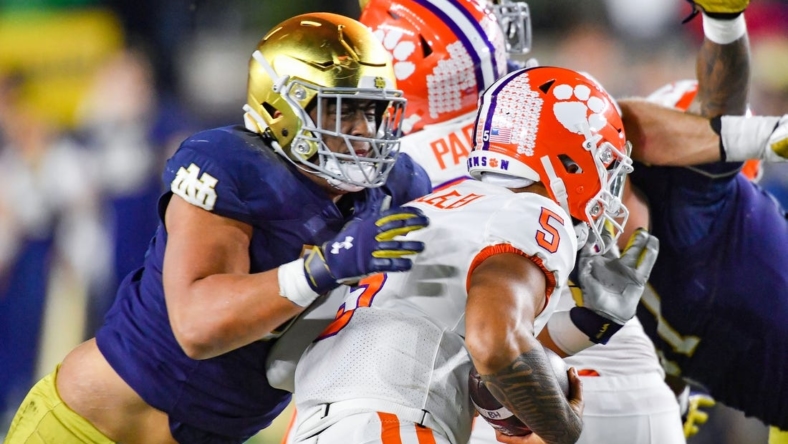 Nov 5, 2022; South Bend, Indiana, USA; Clemson Tigers quarterback DJ Uiagalelei (5) is sacked by Notre Dame Fighting Irish defensive lineman Howard Cross III (56) in the second quarter at Notre Dame Stadium. Mandatory Credit: Matt Cashore-USA TODAY Sports