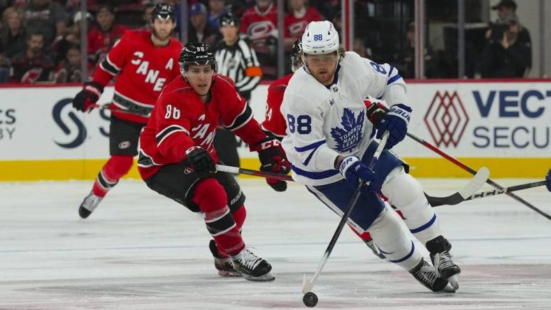 Nov 6, 2022; Raleigh, North Carolina, USA;  Toronto Maple Leafs right wing William Nylander (88) skates with the puck against Carolina Hurricanes left wing Teuvo Teravainen (86) during the first period at PNC Arena. Mandatory Credit: James Guillory-USA TODAY Sports