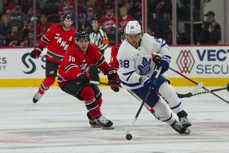 Nov 6, 2022; Raleigh, North Carolina, USA;  Toronto Maple Leafs right wing William Nylander (88) skates with the puck against Carolina Hurricanes left wing Teuvo Teravainen (86) during the first period at PNC Arena. Mandatory Credit: James Guillory-USA TODAY Sports