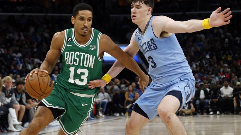 Nov 7, 2022; Memphis, Tennessee, USA; Boston Celtics guard Malcolm Brogdon (13) dribbles as Memphis Grizzlies forward Jake LaRavia (3) defends during the second half at FedExForum. Mandatory Credit: Petre Thomas-USA TODAY Sports