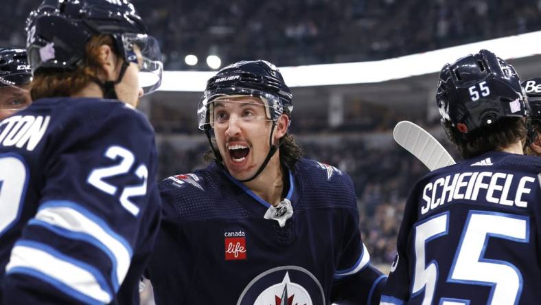 Nov 8, 2022; Winnipeg, Manitoba, CAN; Winnipeg Jets defenseman Brenden Dillon (5) celebrates the second period goal by Winnipeg Jets center Mark Scheifele (55) against the Dallas Stars at Canada Life Centre. Mandatory Credit: James Carey Lauder-USA TODAY Sports