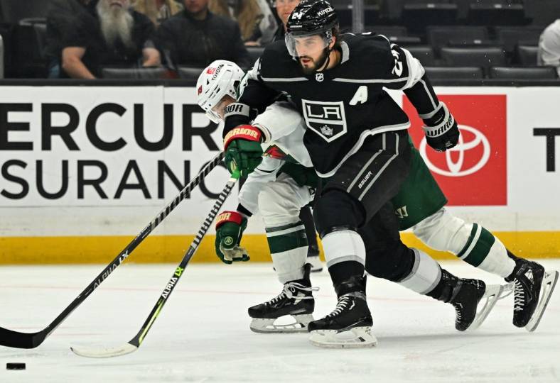 Nov 8, 2022; Los Angeles, California, USA;  Minnesota Wild center Frederick Gaudreau (89) and Los Angeles Kings center Phillip Danault (24) chase down the puck in the first period at Crypto.com Arena. Mandatory Credit: Jayne Kamin-Oncea-USA TODAY Sports