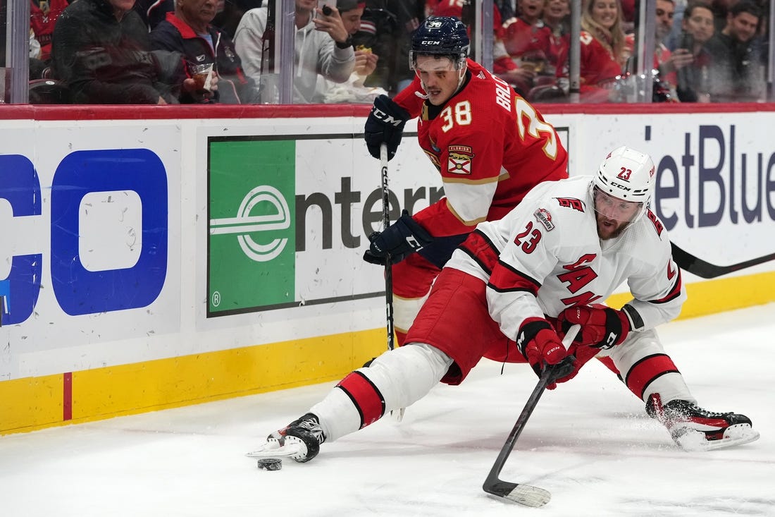 Nov 9, 2022; Sunrise, Florida, USA; Florida Panthers left wing Rudolfs Balcers (38) knocks Carolina Hurricanes right wing Stefan Noesen (23) off the puck during the first period at FLA Live Arena. Mandatory Credit: Jasen Vinlove-USA TODAY Sports