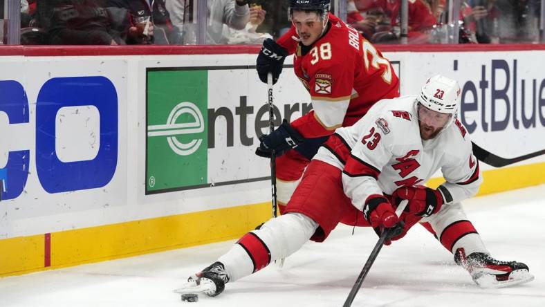 Nov 9, 2022; Sunrise, Florida, USA; Florida Panthers left wing Rudolfs Balcers (38) knocks Carolina Hurricanes right wing Stefan Noesen (23) off the puck during the first period at FLA Live Arena. Mandatory Credit: Jasen Vinlove-USA TODAY Sports