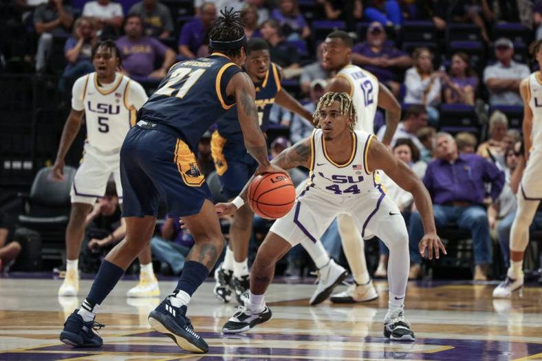 Nov 9, 2022; Baton Rouge, Louisiana, USA; UMKC Kangaroos guard RayQuawndis Mitchell (21) dribbles against LSU Tigers guard Adam Miller (44) during the first half at Pete Maravich Assembly Center. Mandatory Credit: Stephen Lew-USA TODAY Sports