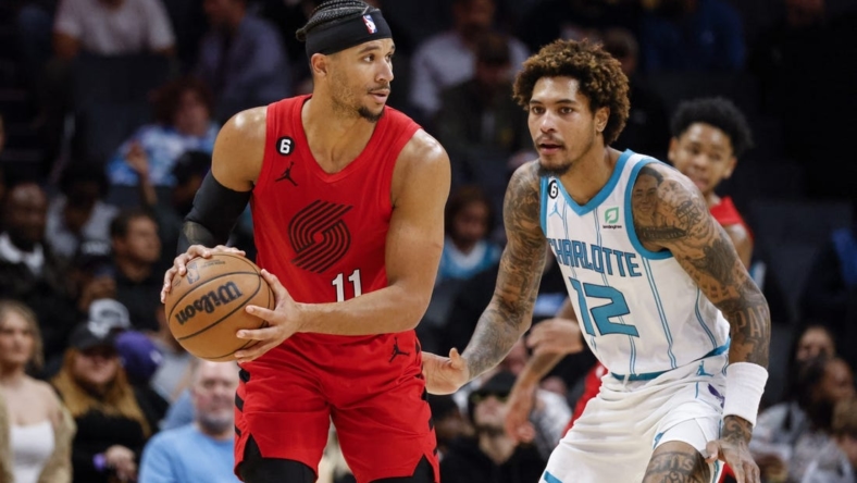 Nov 9, 2022; Charlotte, North Carolina, USA; Portland Trail Blazers guard Josh Hart (11) looks to pass against Charlotte Hornets guard Kelly Oubre Jr. (12) in the second half at Spectrum Center. The Portland Trail Blazers won 105-95. Mandatory Credit: Nell Redmond-USA TODAY Sports