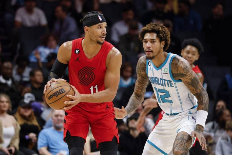 Nov 9, 2022; Charlotte, North Carolina, USA; Portland Trail Blazers guard Josh Hart (11) looks to pass against Charlotte Hornets guard Kelly Oubre Jr. (12) in the second half at Spectrum Center. The Portland Trail Blazers won 105-95. Mandatory Credit: Nell Redmond-USA TODAY Sports