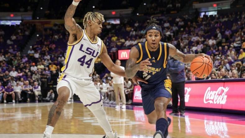 Nov 9, 2022; Baton Rouge, Louisiana, USA; UMKC Kangaroos guard RayQuawndis Mitchell (21) dribbles against LSU Tigers guard Adam Miller (44) during the second half at Pete Maravich Assembly Center. Mandatory Credit: Stephen Lew-USA TODAY Sports