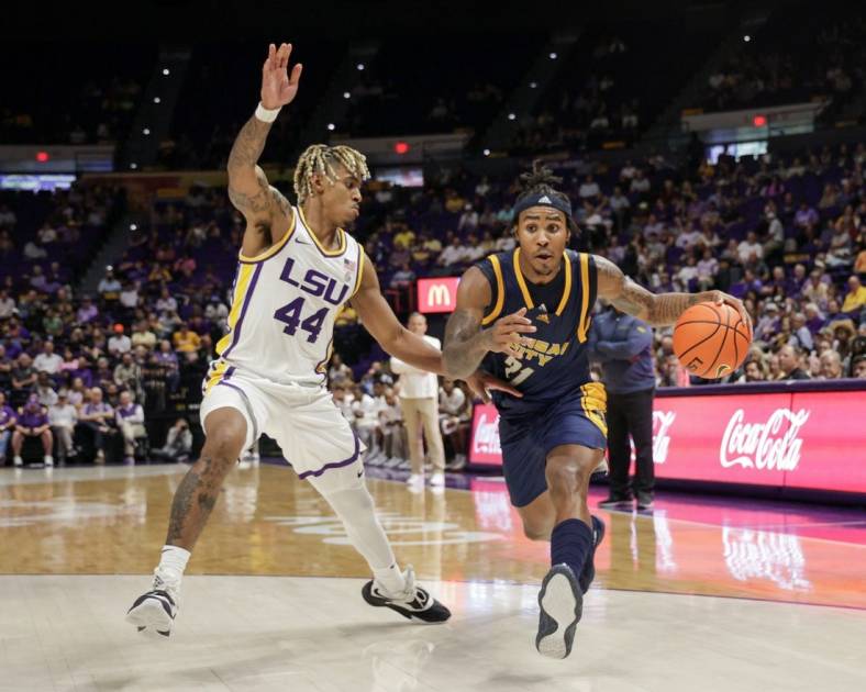 Nov 9, 2022; Baton Rouge, Louisiana, USA; UMKC Kangaroos guard RayQuawndis Mitchell (21) dribbles against LSU Tigers guard Adam Miller (44) during the second half at Pete Maravich Assembly Center. Mandatory Credit: Stephen Lew-USA TODAY Sports