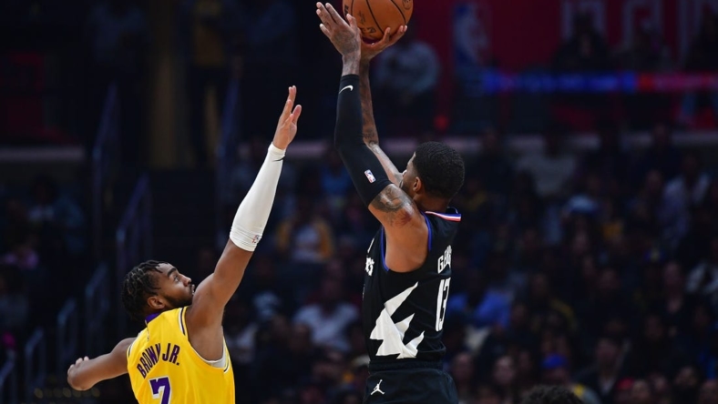 Nov 9, 2022; Los Angeles, California, USA; Los Angeles Clippers guard Paul George (13) shoots against Los Angeles Lakers forward Troy Brown Jr. (7) during the first half at Crypto.com Arena. Mandatory Credit: Gary A. Vasquez-USA TODAY Sports