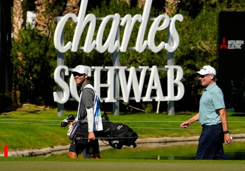 Nov 10, 2022; Phoenix, AZ, USA; John Huston (right) walks off the 18th hole smiling after shooting 6-under-par during round one of the Charles Schwab Cup at Phoenix Country Club. Mandatory Credit: Rob Schumacher-USA TODAY Sports