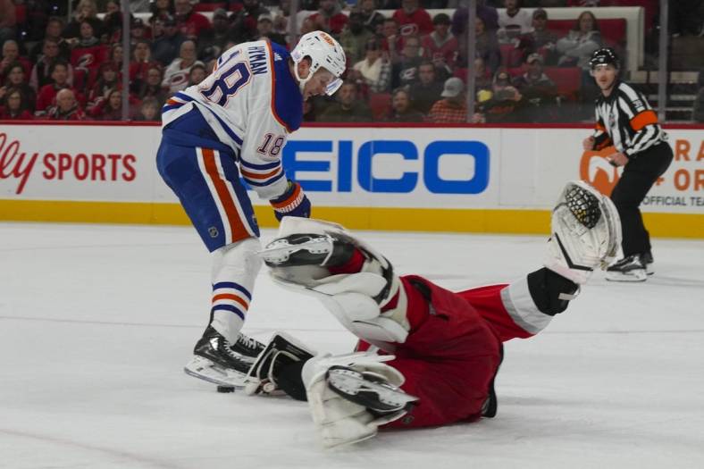 Nov 10, 2022; Raleigh, North Carolina, USA;  Carolina Hurricanes goaltender Pyotr Kochetkov (center) stops the breakaway attempt by Edmonton Oilers left wing Zach Hyman (18) during the second period at PNC Arena. Mandatory Credit: James Guillory-USA TODAY Sports