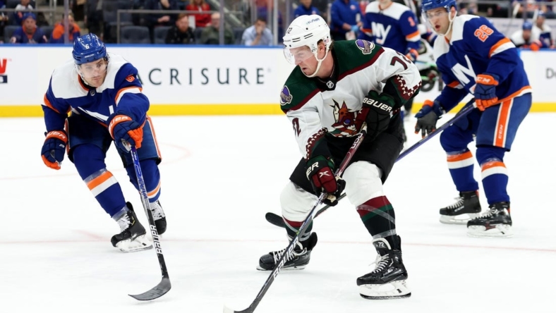 Nov 10, 2022; Elmont, New York, USA; Arizona Coyotes center Travis Boyd (72) controls the puck against New York Islanders defenseman Ryan Pulock (6) and right wing Oliver Wahlstrom (26) during the third period at UBS Arena. Mandatory Credit: Brad Penner-USA TODAY Sports