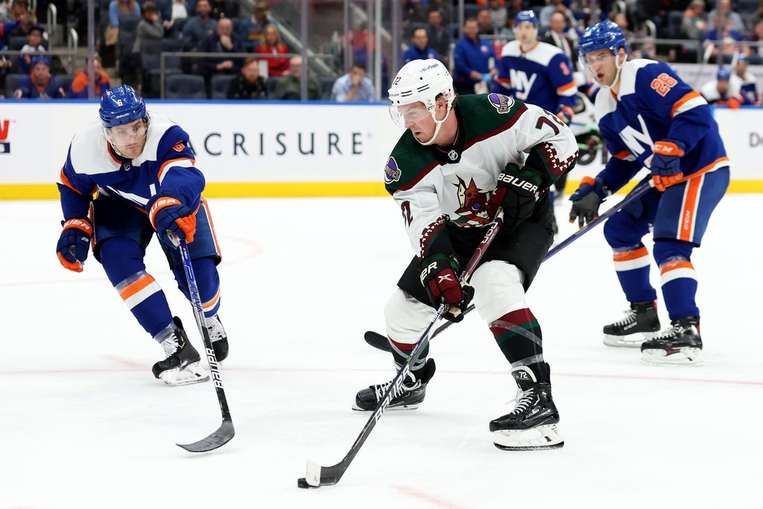 Nov 10, 2022; Elmont, New York, USA; Arizona Coyotes center Travis Boyd (72) controls the puck against New York Islanders defenseman Ryan Pulock (6) and right wing Oliver Wahlstrom (26) during the third period at UBS Arena. Mandatory Credit: Brad Penner-USA TODAY Sports