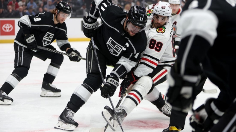 Nov 10, 2022; Los Angeles, California, USA; Los Angeles Kings center Anze Kopitar (11) and Chicago Blackhawks center Andreas Athanasiou (89) battle for the puck during the first period at Crypto.com Arena. Mandatory Credit: Kiyoshi Mio-USA TODAY Sports