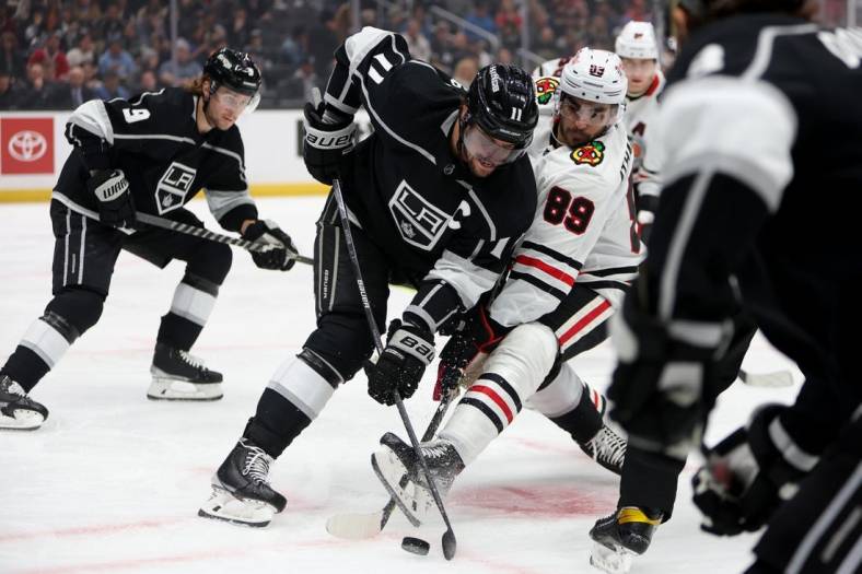 Nov 10, 2022; Los Angeles, California, USA; Los Angeles Kings center Anze Kopitar (11) and Chicago Blackhawks center Andreas Athanasiou (89) battle for the puck during the first period at Crypto.com Arena. Mandatory Credit: Kiyoshi Mio-USA TODAY Sports