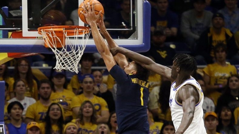 Nov 11, 2022; Pittsburgh, Pennsylvania, USA;  West Virginia Mountaineers forward Emmitt Matthews Jr. (1) dunks the ball past Pittsburgh Panthers center Federiko Federiko (right) during the first half at the Petersen Events Center. Mandatory Credit: Charles LeClaire-USA TODAY Sports