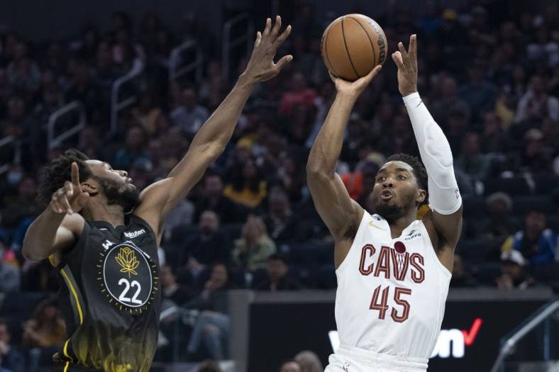 November 11, 2022; San Francisco, California, USA; Cleveland Cavaliers guard Donovan Mitchell (45) shoots the basketball against Golden State Warriors forward Andrew Wiggins (22) during the second quarter at Chase Center. Mandatory Credit: Kyle Terada-USA TODAY Sports