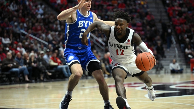 Nov 11, 2022; San Diego, California, USA; San Diego State Aztecs guard Darrion Trammell (12) dribbles the ball while defended by Brigham Young Cougars guard Spencer Johnson (20) during the first half at Viejas Arena. Mandatory Credit: Orlando Ramirez-USA TODAY Sports