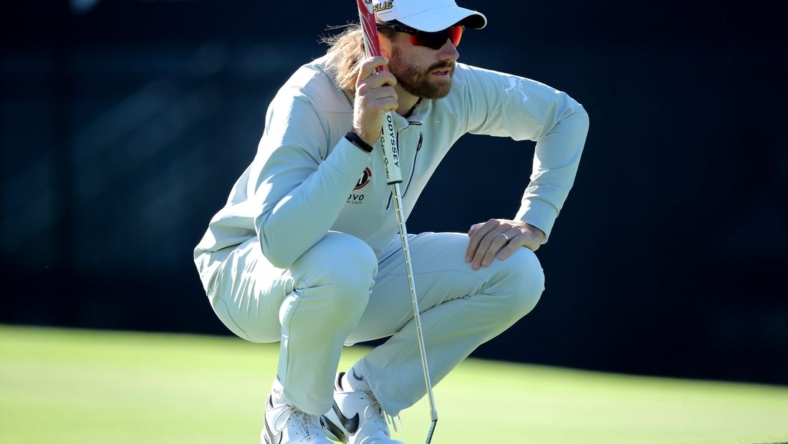 Nov 12, 2022; Houston, Texas, USA; Patrick Rodgers kneels on the green while waiting to putt on the ninth hole during the third round of the Cadence Bank Houston Open golf tournament. Mandatory Credit: Erik Williams-USA TODAY Sports