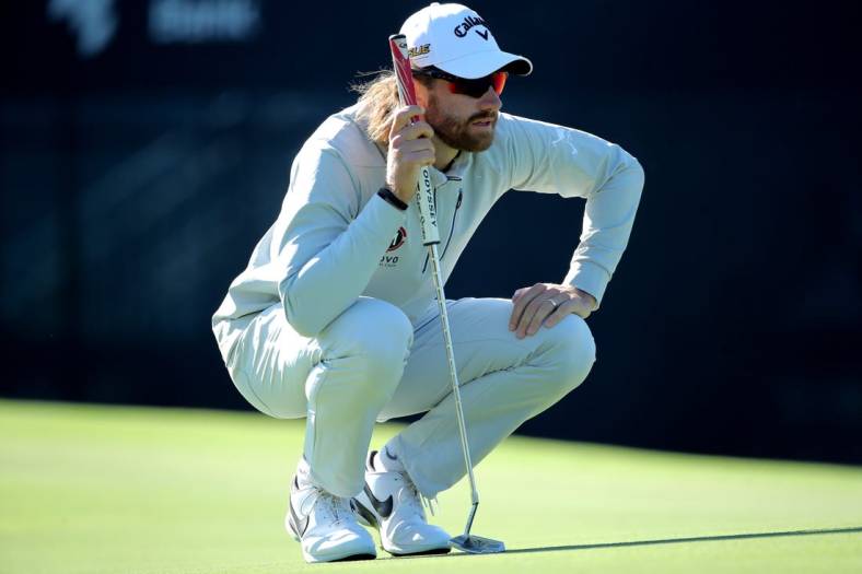 Nov 12, 2022; Houston, Texas, USA; Patrick Rodgers kneels on the green while waiting to putt on the ninth hole during the third round of the Cadence Bank Houston Open golf tournament. Mandatory Credit: Erik Williams-USA TODAY Sports