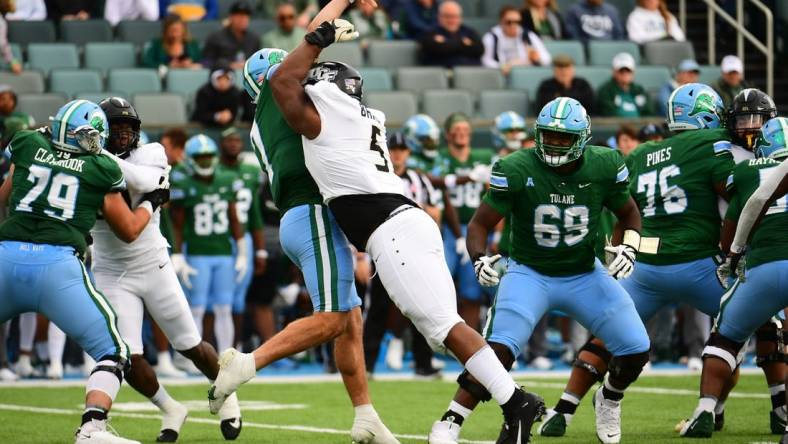 Nov 12, 2022; New Orleans, Louisiana, USA; UCF Knights defensive tackle Ricky Barber (5) sacks Tulane Green Wave quarterback Michael Pratt (7) during the first quarter at Yulman Stadium. Mandatory Credit: Rebecca Warren-USA TODAY Sports