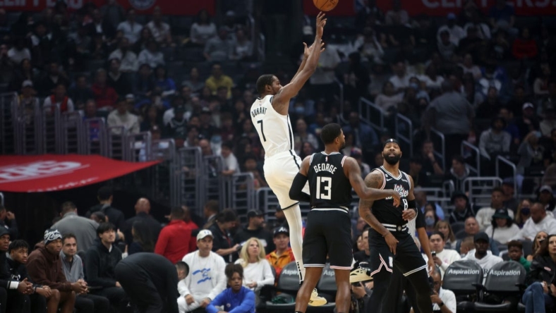 Nov 12, 2022; Los Angeles, California, USA;  Brooklyn Nets forward Kevin Durant (7) shoots a ball against LA Clippers guard Paul George (13) and forward Marcus Morris Sr. (8) during the first quarter at Crypto.com Arena. Mandatory Credit: Kiyoshi Mio-USA TODAY Sports