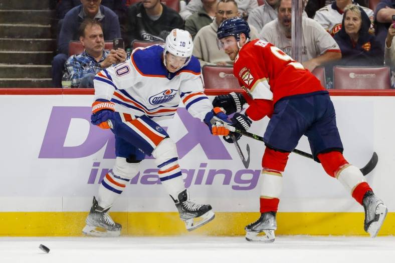 Nov 12, 2022; Sunrise, Florida, USA; Edmonton Oilers center Derek Ryan (10) clears the puck away from Florida Panthers center Sam Bennett (9) during the first period at FLA Live Arena. Mandatory Credit: Sam Navarro-USA TODAY Sports