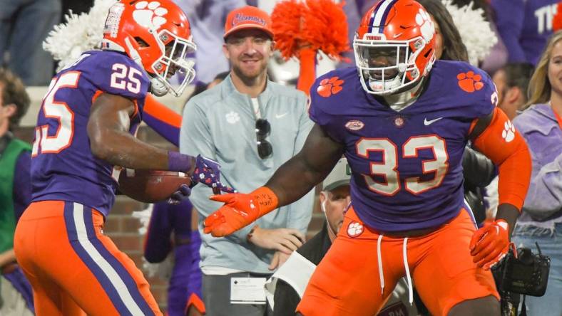 Nov 12, 2022; Clemson, South Carolina, USA; Clemson safety Jalyn Phillips (25) celebrates a fumble recovery defensive tackle Ruke Orhorhoro (33)  playing Louisville during the third quarter at Memorial Stadium in Clemson, South Carolina Saturday, Nov. 12, 2022.     Mandatory Credit: Ken Ruinard-USA TODAY Sports