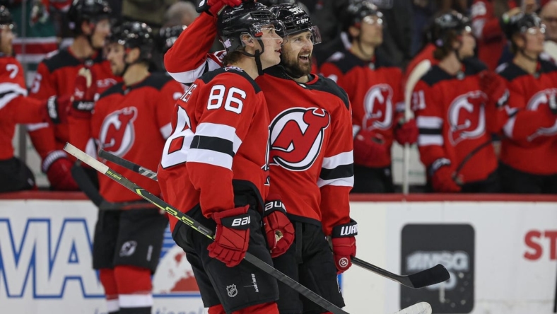 Nov 12, 2022; Newark, New Jersey, USA; New Jersey Devils center Jack Hughes (86) and left wing Tomas Tatar (90) look up at the main scoreboard after a goal against the Arizona Coyotes during the first period at Prudential Center. Mandatory Credit: Vincent Carchietta-USA TODAY Sports