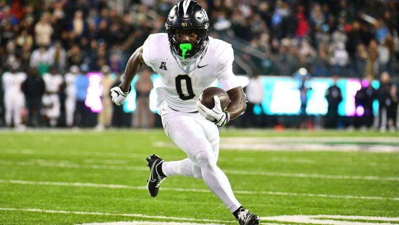 Nov 12, 2022; New Orleans, Louisiana, USA; UCF Knights running back Johnny Richardson (0) runs the ball against the Tulane Green Wave during the fourth quarter at Yulman Stadium. Mandatory Credit: Rebecca Warren-USA TODAY Sports