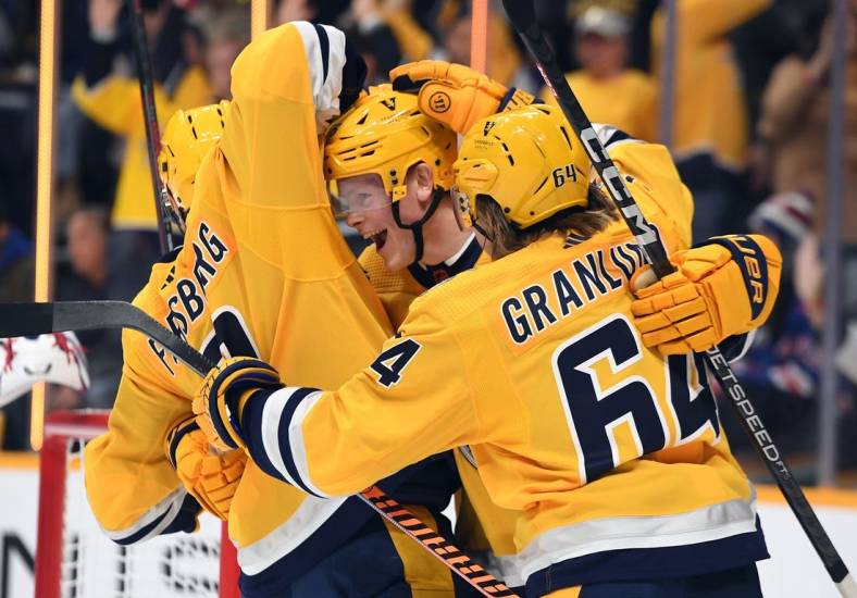 Nov 12, 2022; Nashville, Tennessee, USA; Nashville Predators center Juuso Parssinen (75) celebrates with left wing Filip Forsberg (9) and center Mikael Granlund (64) after scoring his first career goal during the first period against the New York Rangers at Bridgestone Arena. Mandatory Credit: Christopher Hanewinckel-USA TODAY Sports