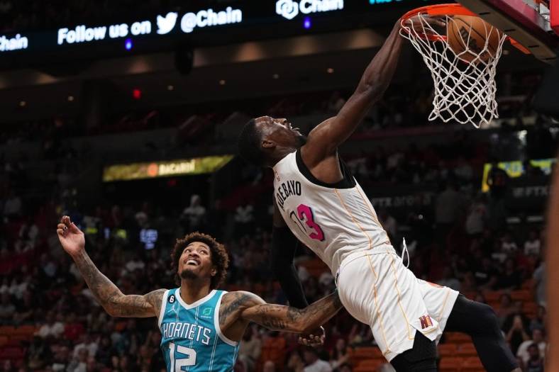 Nov 12, 2022; Miami, Florida, USA; Miami Heat center Bam Adebayo (13) dunks the ball over Charlotte Hornets guard Kelly Oubre Jr. (12) during the second half at FTX Arena. Mandatory Credit: Jasen Vinlove-USA TODAY Sports