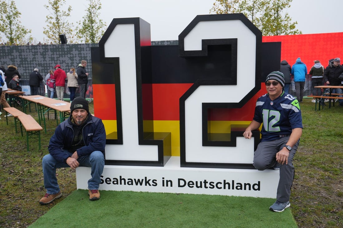 Nov 13, 2022; Munich, Germany; Seattle Seahawks fans pose with 12th Man display at the gameday plaza before an NFL International Series game at Allianz Arena. Mandatory Credit: Kirby Lee-USA TODAY Sports