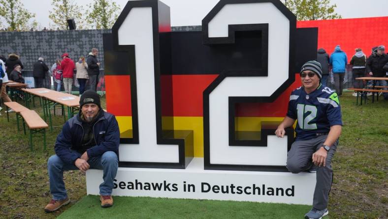 Nov 13, 2022; Munich, Germany; Seattle Seahawks fans pose with 12th Man display at the gameday plaza before an NFL International Series game at Allianz Arena. Mandatory Credit: Kirby Lee-USA TODAY Sports