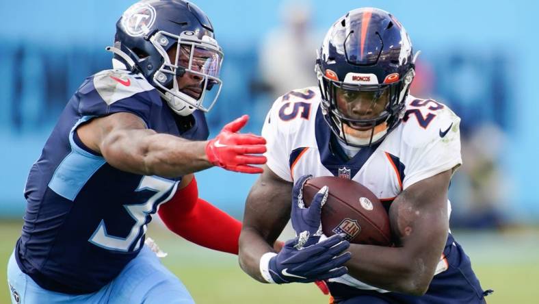 Nov 13, 2022; Nashville, Tennessee, USA; Denver Broncos running back Melvin Gordon III (25) gets tackled by Tennessee Titans safety Kevin Byard (31) during the fourth quarter at Nissan Stadium. Mandatory Credit: Andrew Nelles-USA TODAY Sports