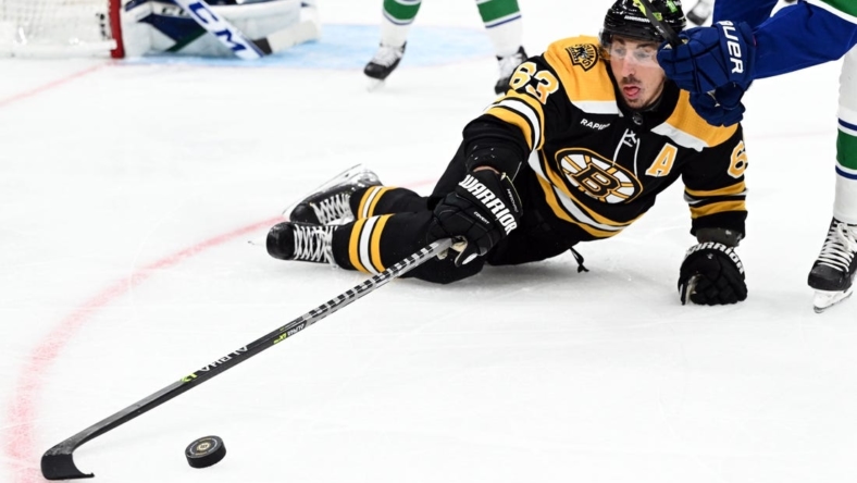 Nov 13, 2022; Boston, Massachusetts, USA; Boston Bruins left wing Brad Marchand (63) passes the puck after failing to the ice during the first period of a game against the Vancouver Canucks at the TD Garden. Mandatory Credit: Brian Fluharty-USA TODAY Sports