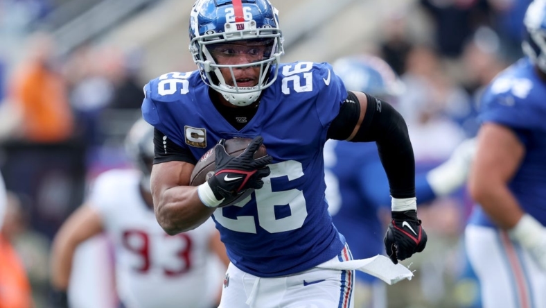 Nov 13, 2022; East Rutherford, New Jersey, USA; New York Giants running back Saquon Barkley (26) runs with the ball against the Houston Texans during the first quarter at MetLife Stadium. Mandatory Credit: Brad Penner-USA TODAY Sports
